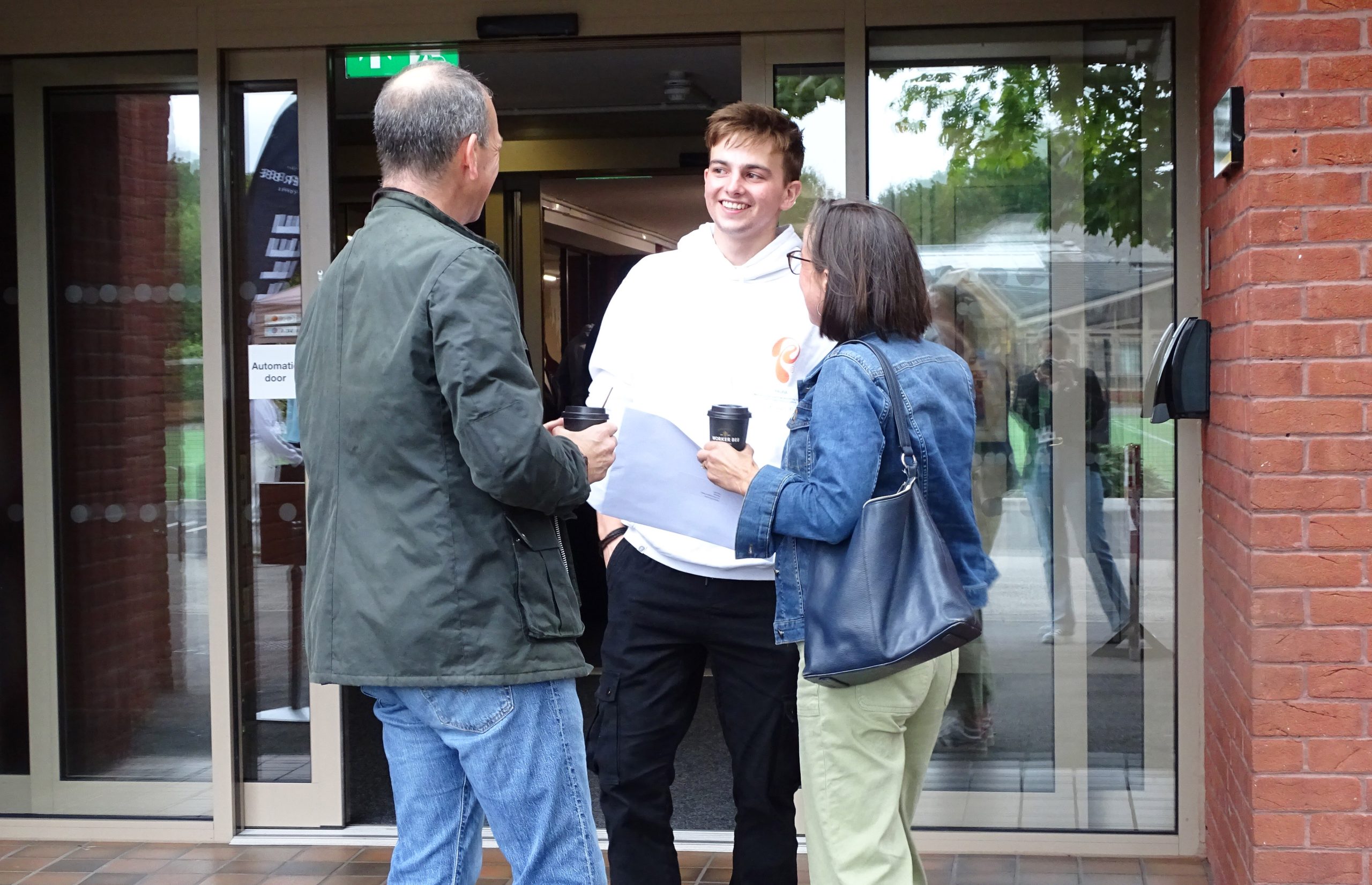 Student smiling with parents during the 2024 A Level Results Day