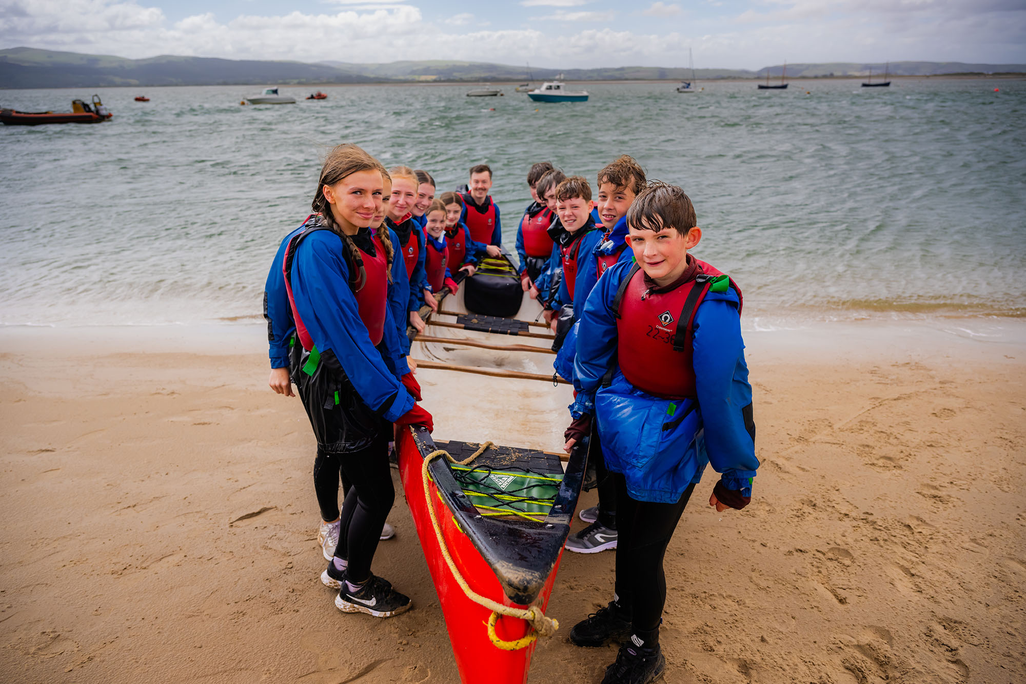 Pupils carrying a boat during their trip to Aberdovey