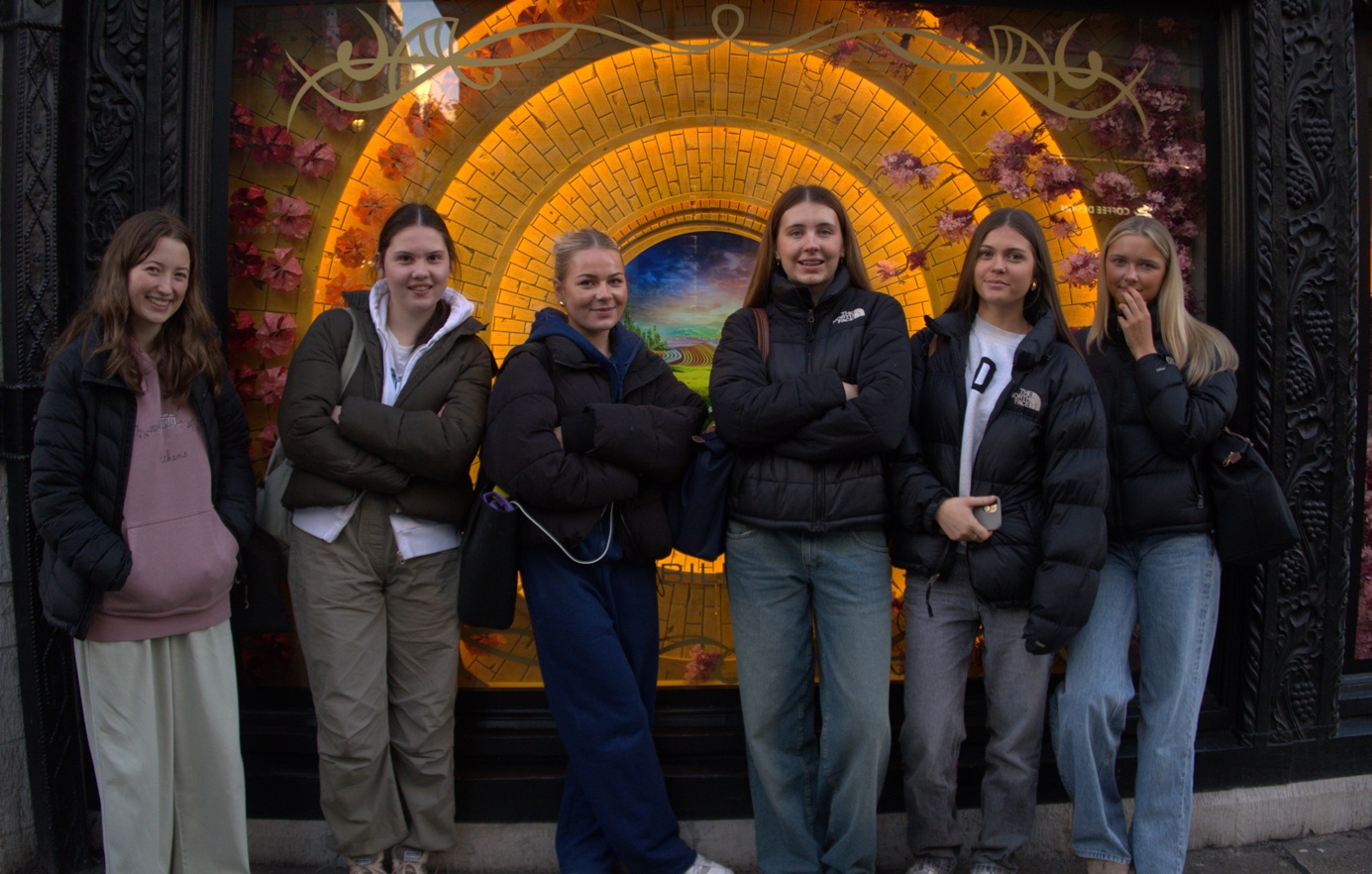 Students pose outside a shop during their art trip to London