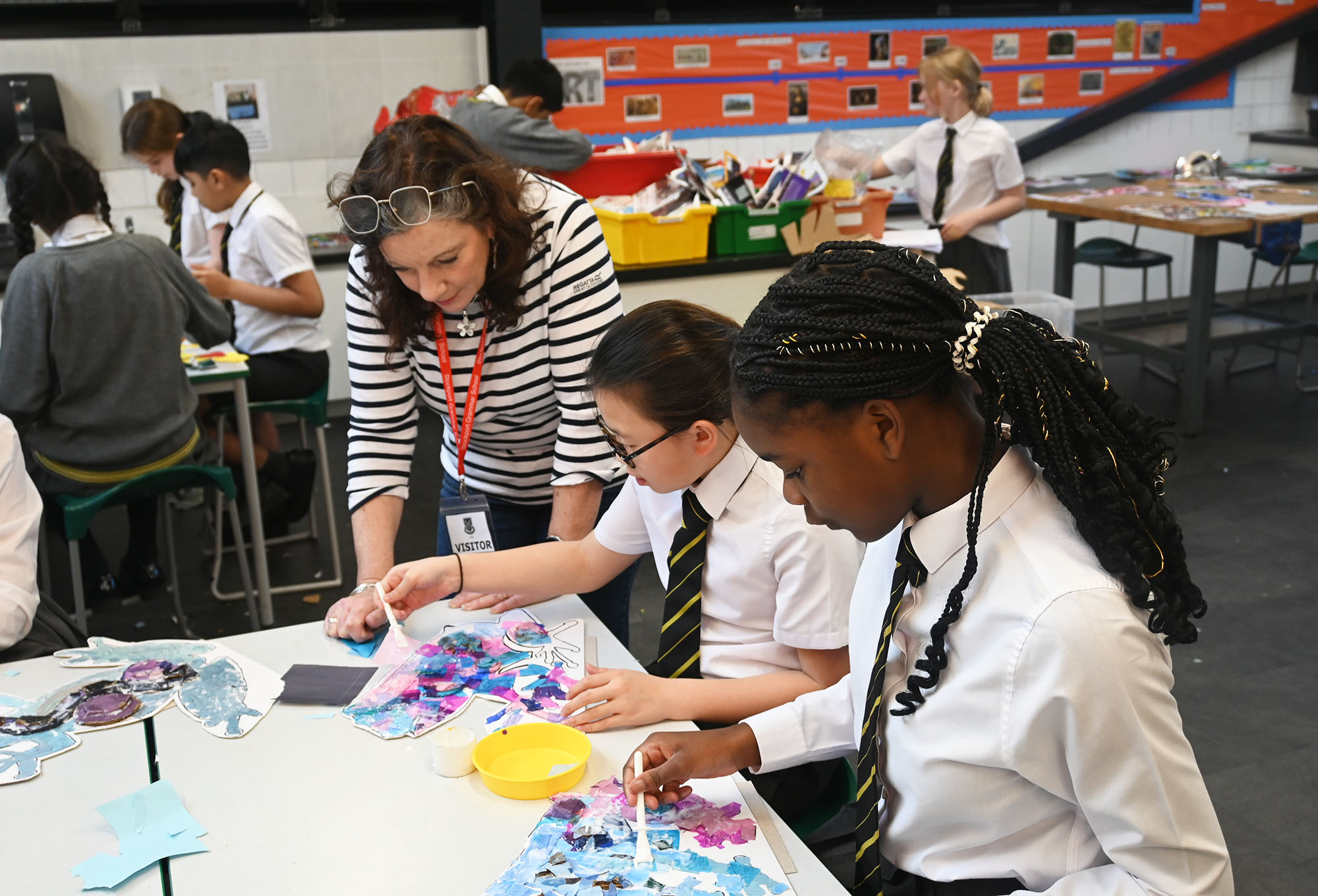 Artist Lucy Burgess helping Year 6 girls with their frog collage project