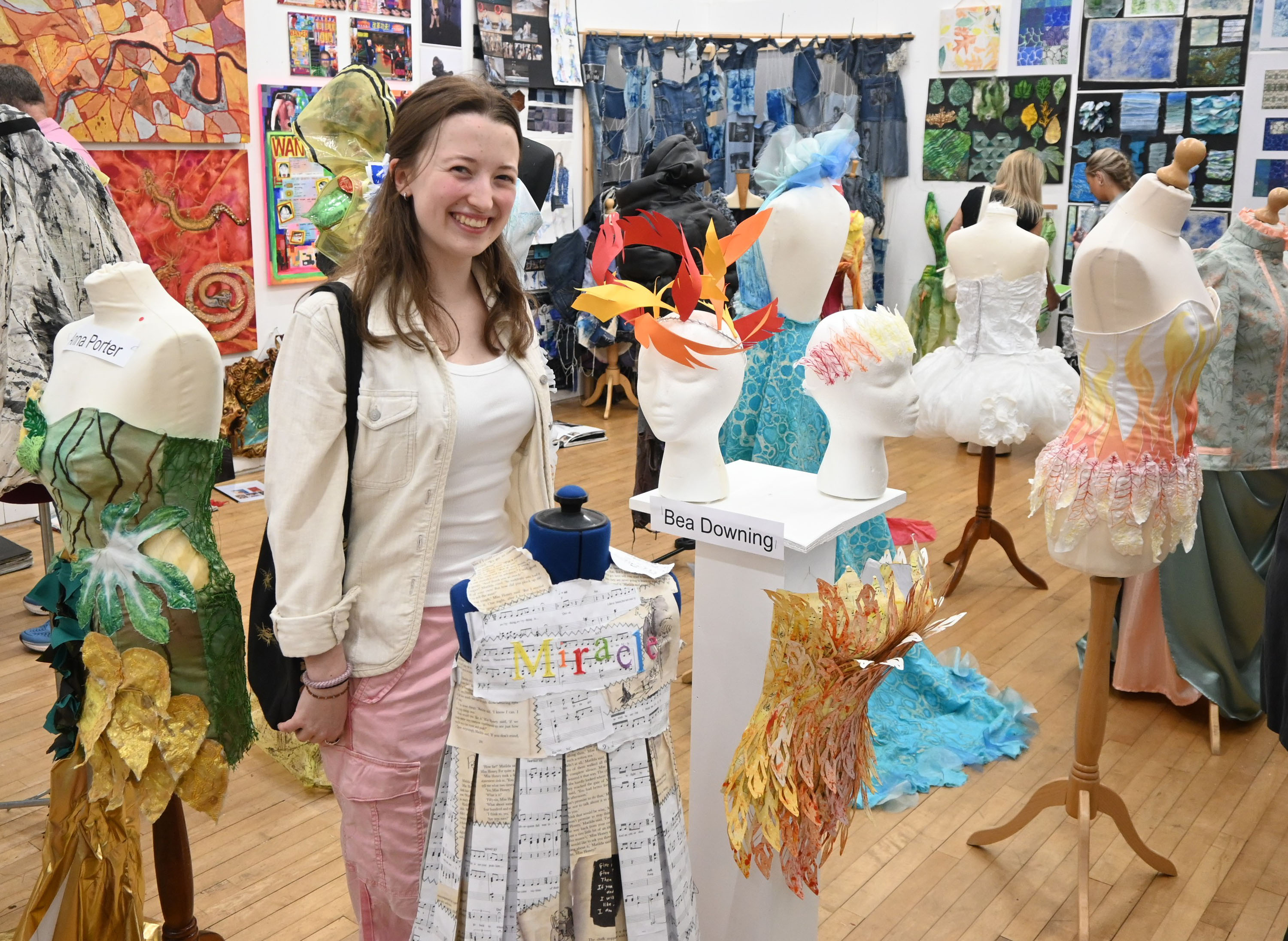 Pupil standing with her work at the Art Exhibition 2025