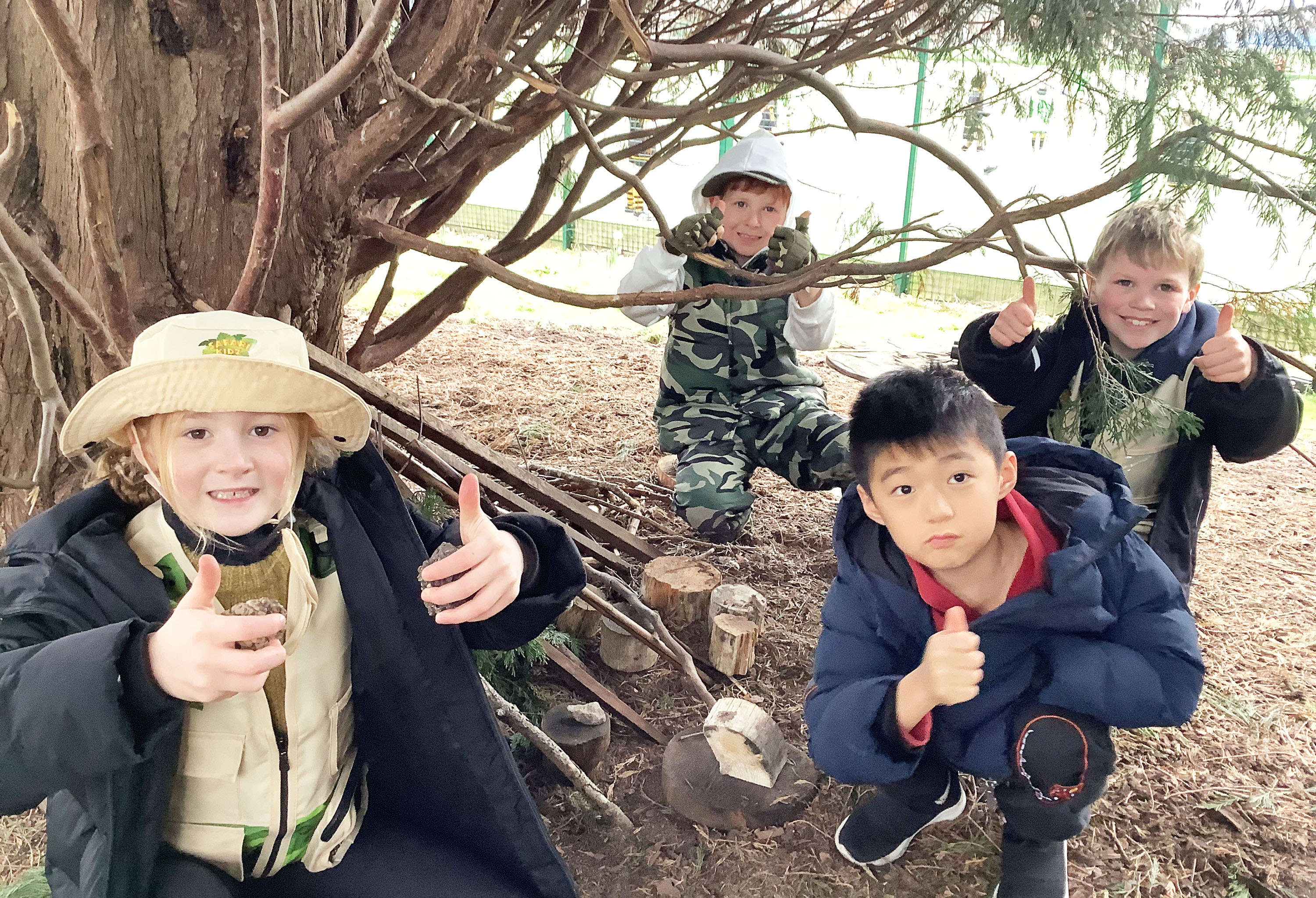 Year 2 pupils pose for a photo in the forest area during their Explorer Day
