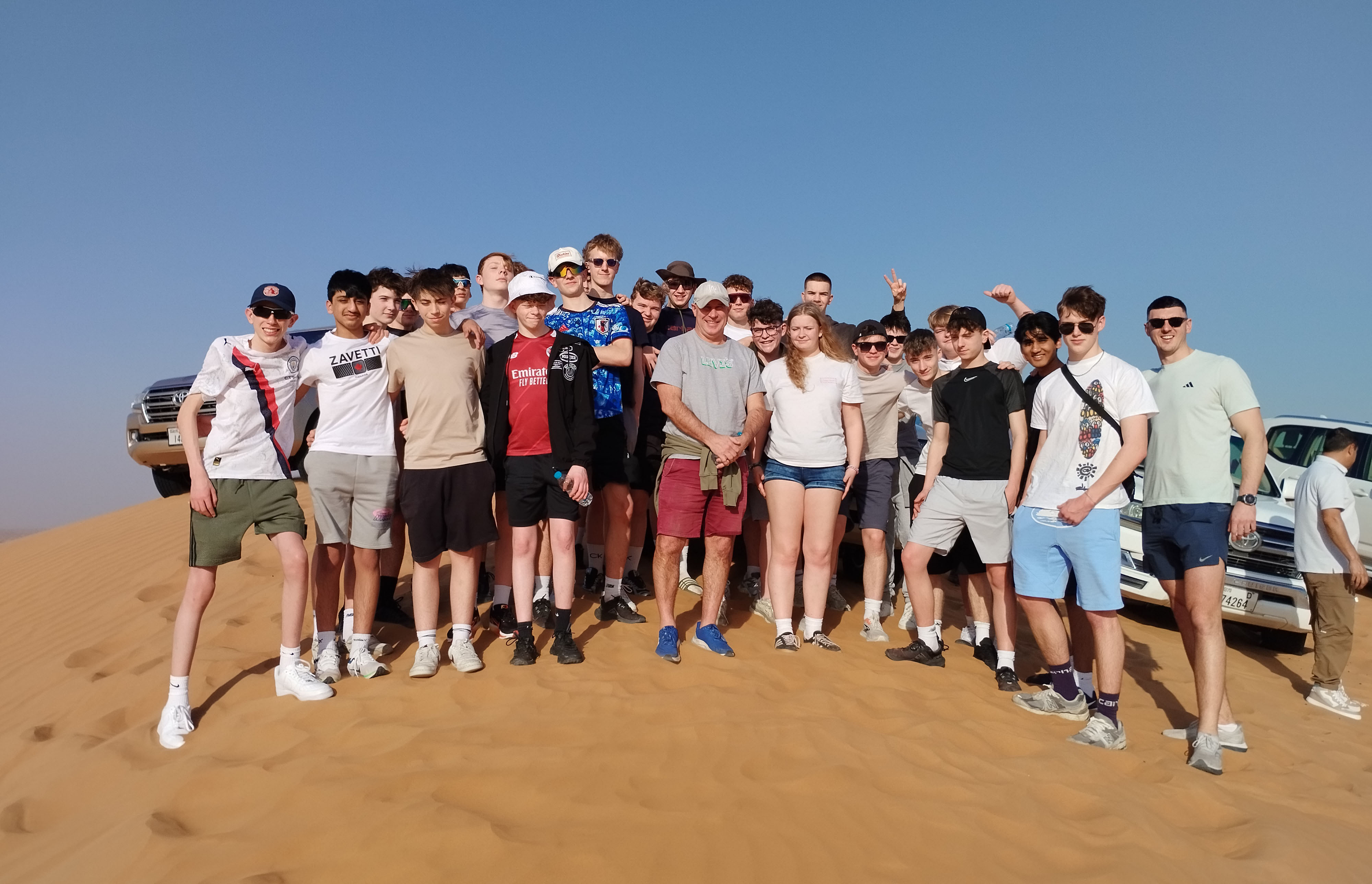 Pupils on the 2026 Senior cricket tour to Dubai pose for a photo on the sand dunes
